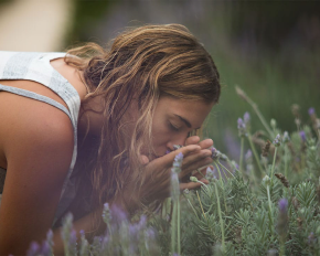 Mujer oliendo lavanda en el jardín del Hostal Empúries