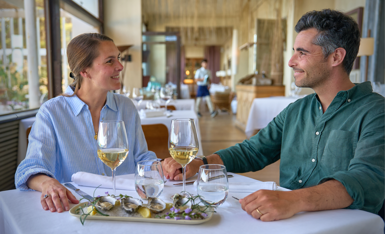 Pareja cenando en la terraza del restaurante con vistas al mar