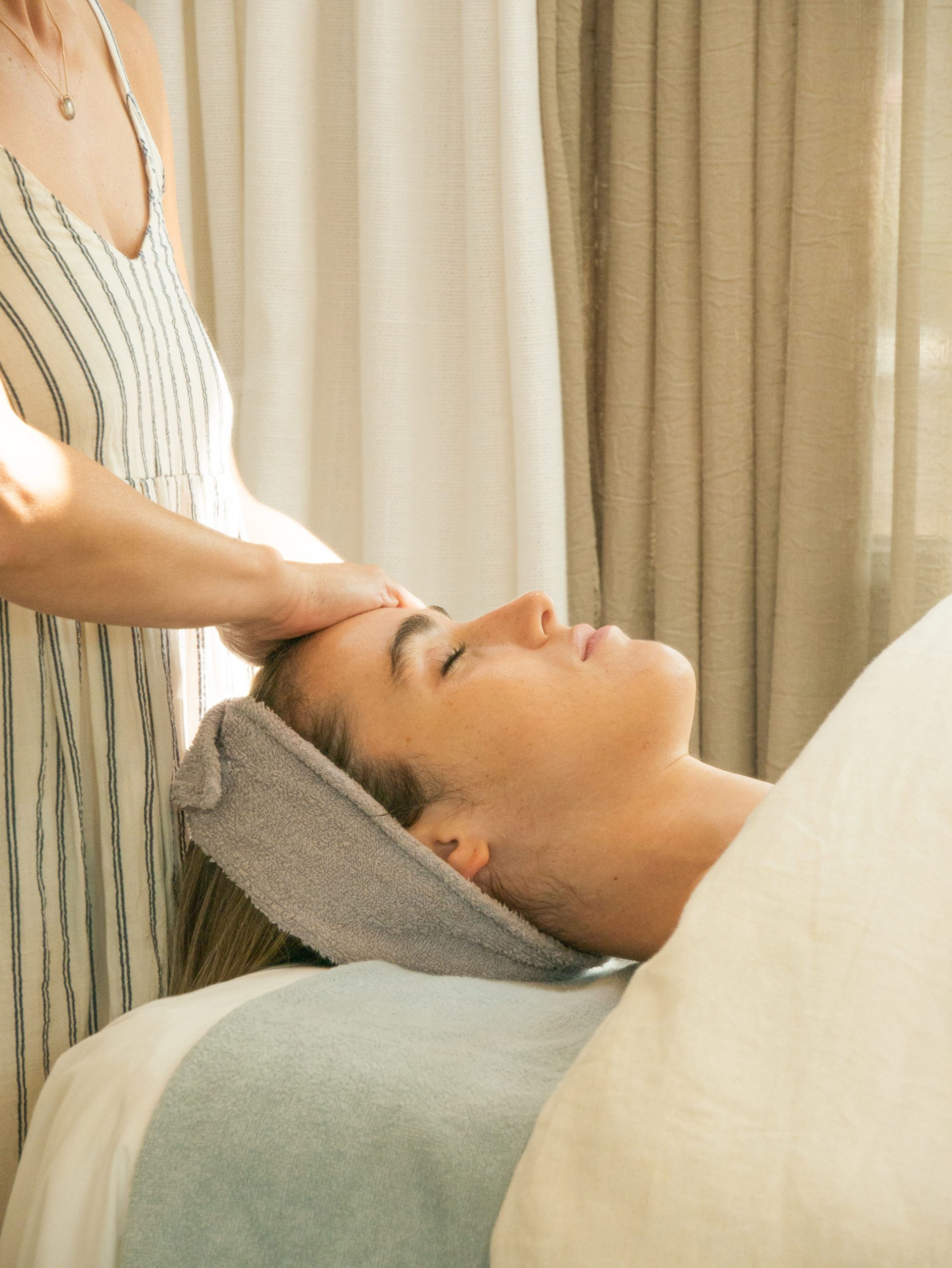 Terapeuta aplicando un tratamiento facial con toalla en el Spa Hostal Empúries